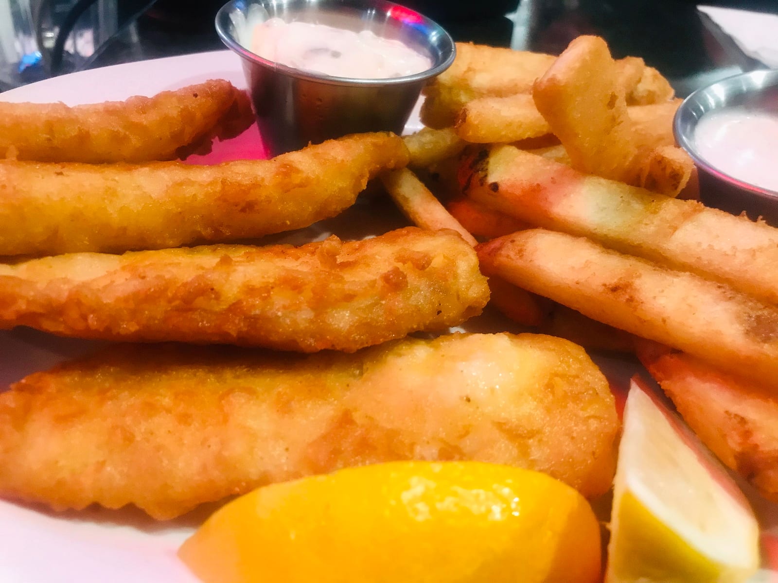 Beer battered fish strips with fries, lemon wedges and tartar sauce