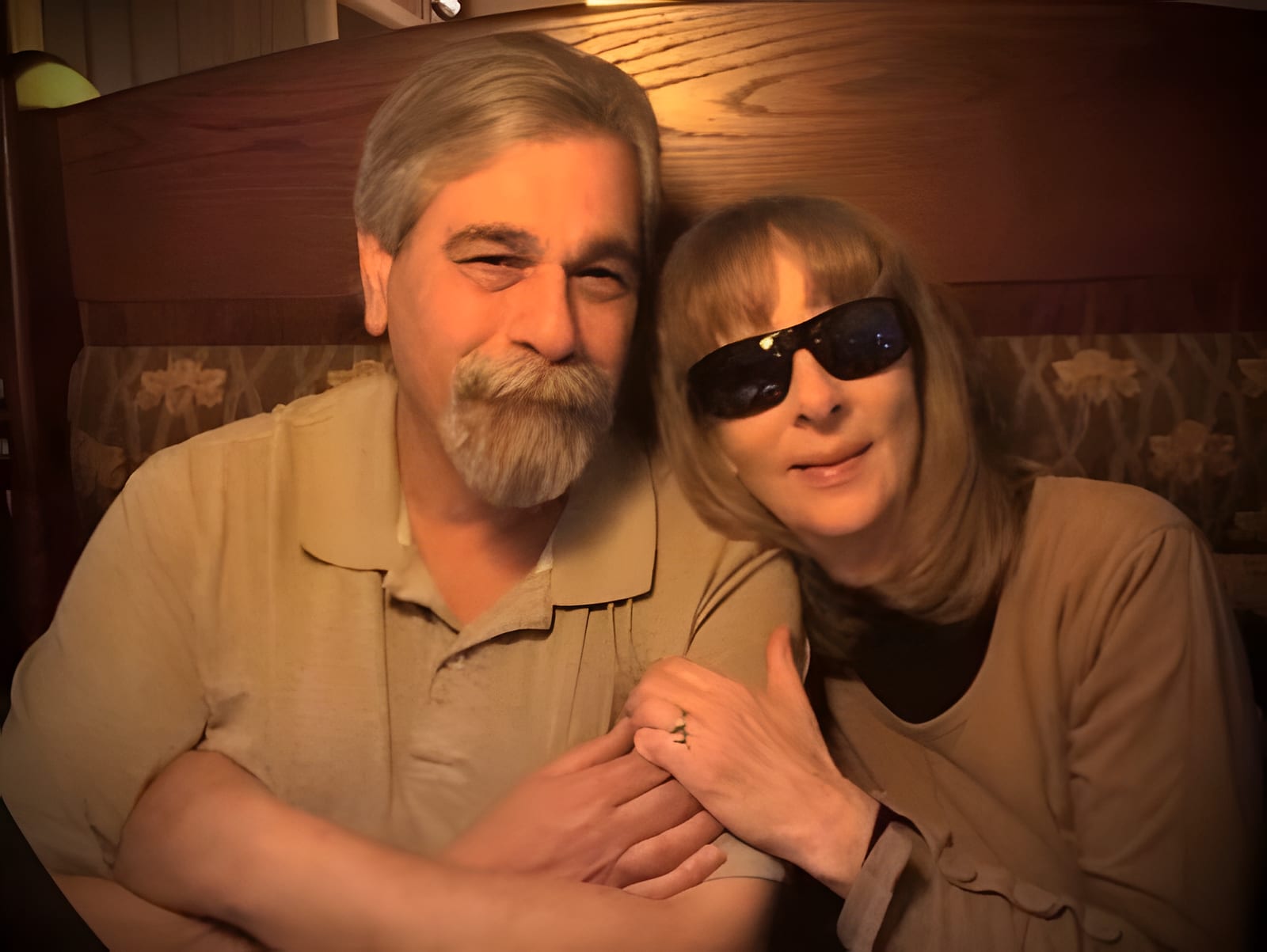 A man and a woman sitting close together in a wooden booth at Joe's