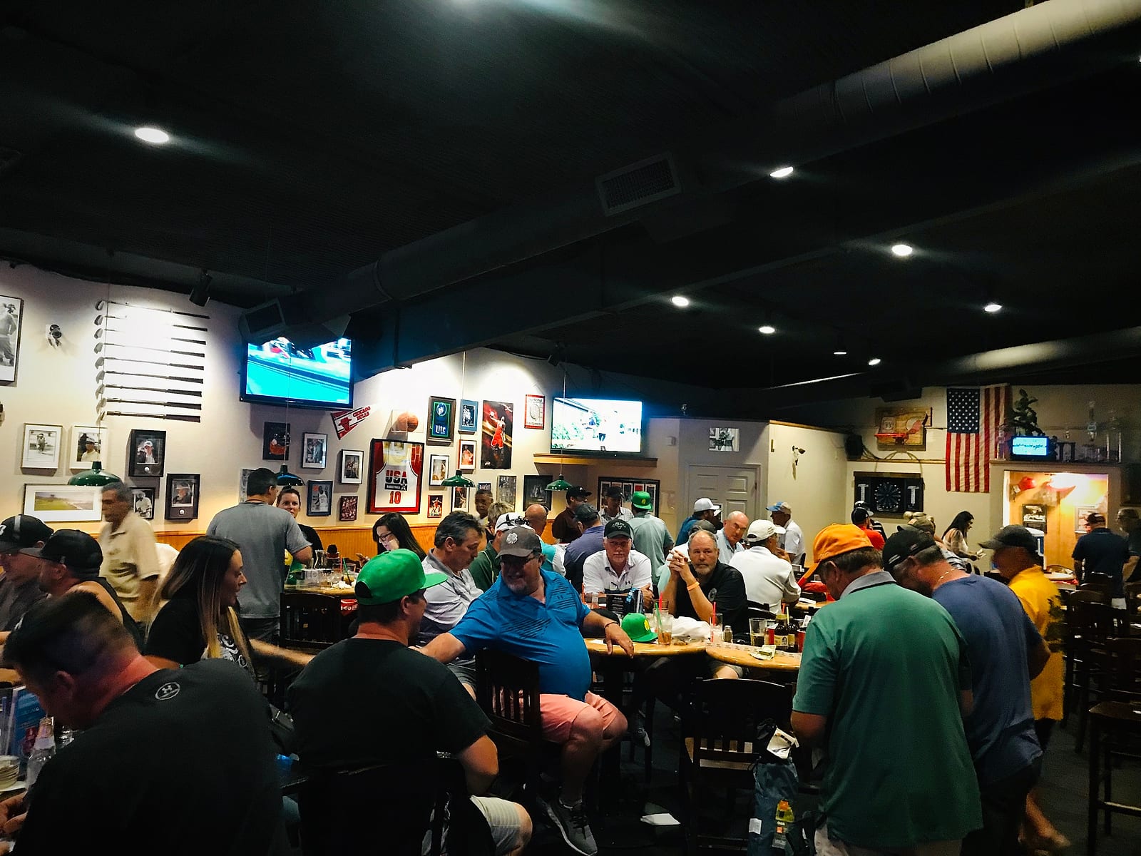 Joe's dining room packed with guests at tables, TVs lining the walls
