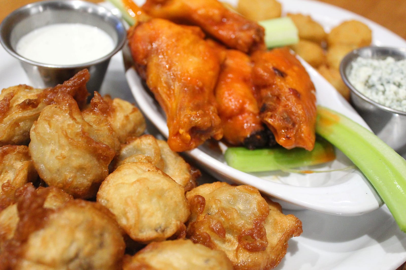 Buffalo wings with celery, fried mushrooms and dipping sauces